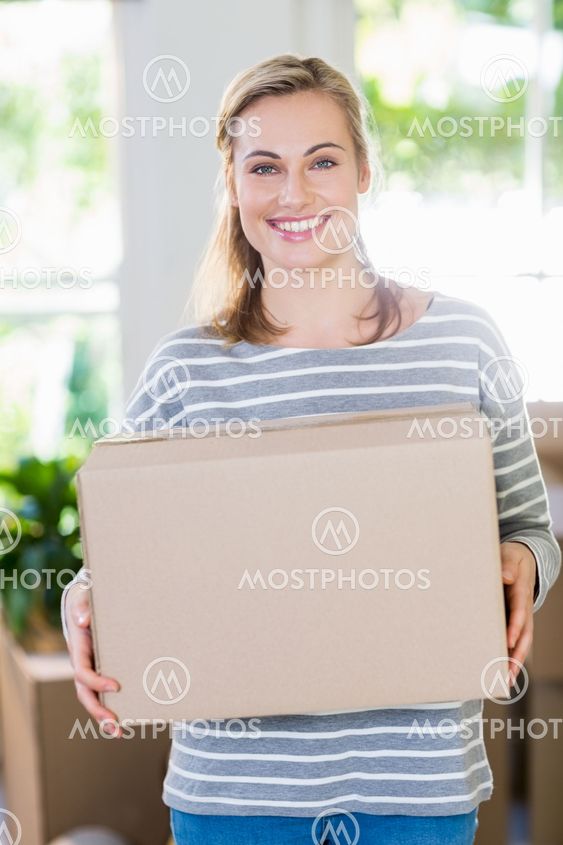 Portrait of young woman holding cardboard boxes