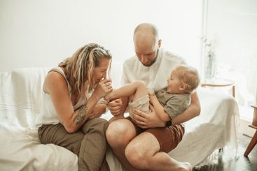 Parents, kids and a family laughing on the sofa in the...