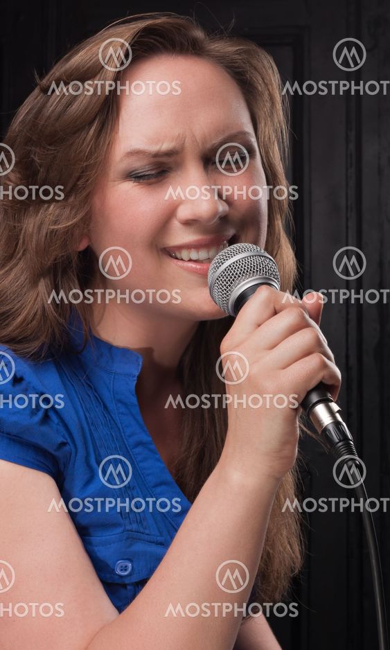 Girl singing to the microphone in a studio