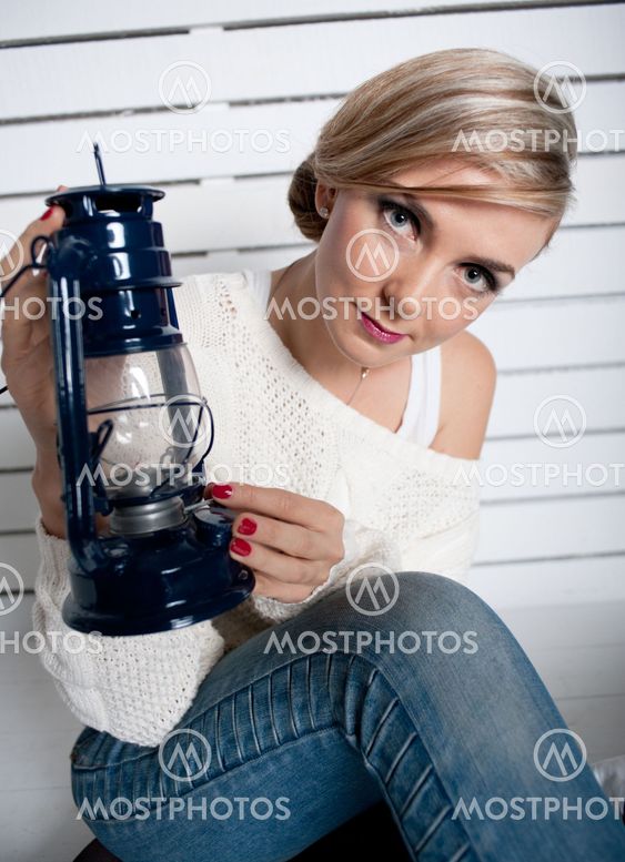the young girl holds an oil lamp