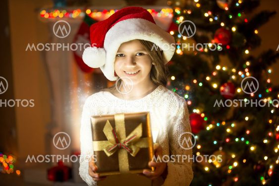 smiling girl posing with shining gift box against...