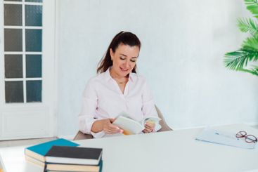 Brunette businesswoman sitting at desk in office with...