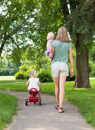 Mother With Children Strolling In Park