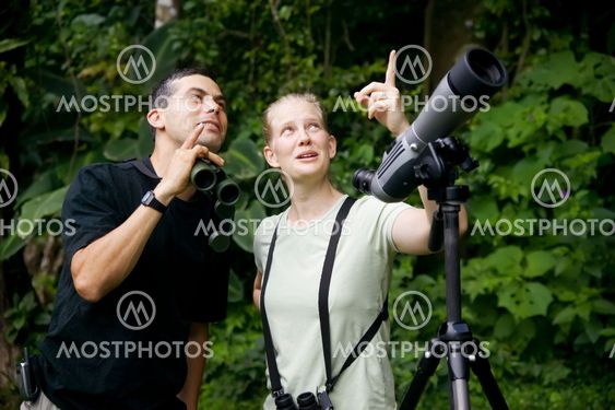 Pretty Woman with Binoculars and Man with Telescope in...