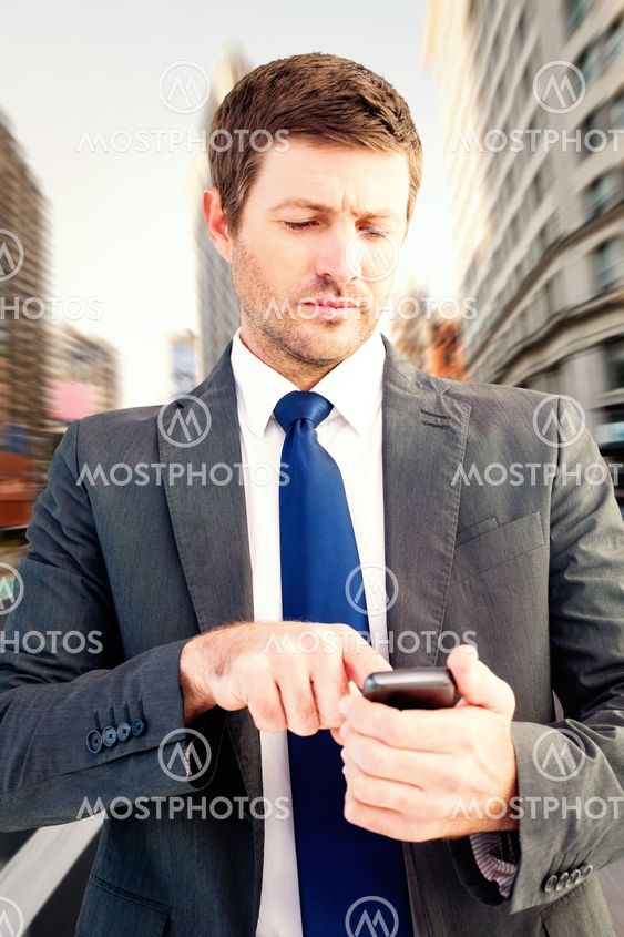 Composite image of businessman sending a text message