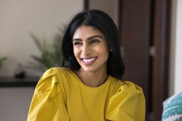 Headshot of beautiful Indian woman sitting indoor with...