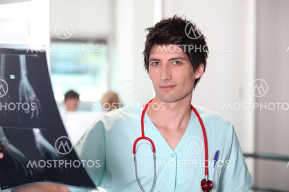 Male nurse examining x-ray image