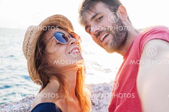 Young couple taking a selfie by the sea