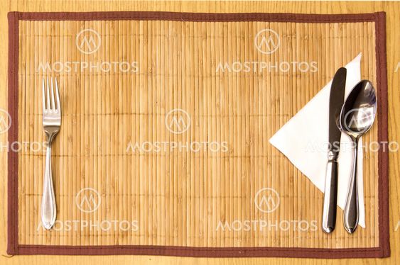 Table appointments- fork,knife,spoon, silk napkin on bamboo mat