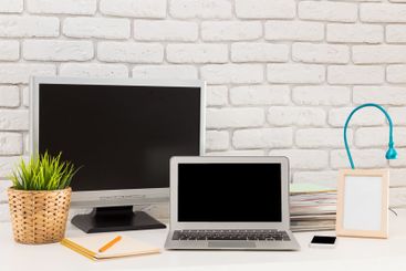 Workstation setup with a laptop, monitor, and stationery...