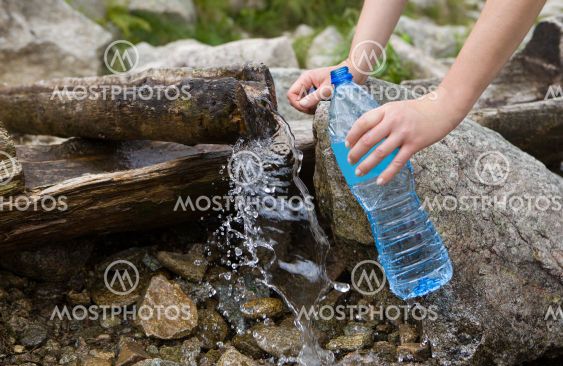 Taking spring water from a mountain spring.