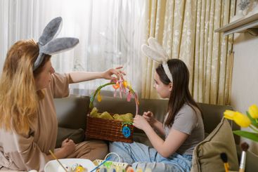 Mother and daughter decorating an Easter basket together.
