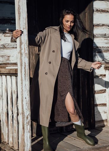 Beautiful brunette woman in gray coat at the door on the...
