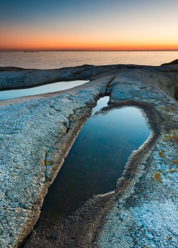 Breathtaking sunset over Sweden's coastal rocks and...