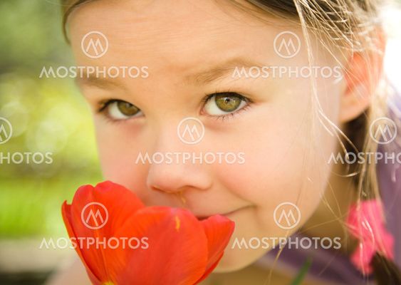 Portrait of a cute little girl smelling flowers