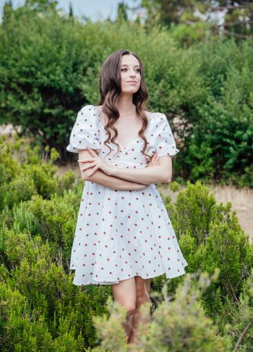 Beautiful brunette woman in summer dress walking in the...