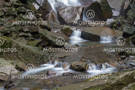 Water flowing over stones. By base of waterfall.