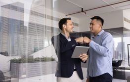 Two positive male business colleagues enjoying...