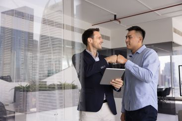 Two positive male business colleagues enjoying...