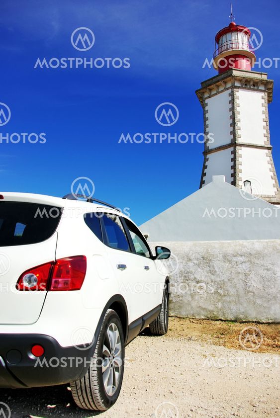 White car near Lighthouse of Espichel cape, Portugal.