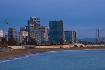 Cityscape of Barcelona at dusk with beach, buildings,...
