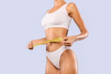 Closeup of Unrecognizable Lady Measuring Waist With Tape