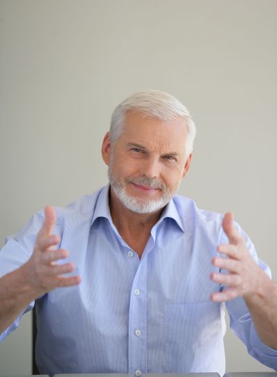 Elderly man holding up his hands