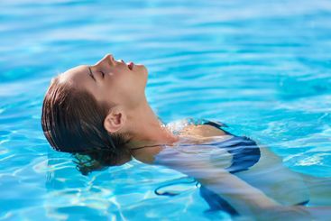 Swimming pool, woman and relax in water on holiday,...