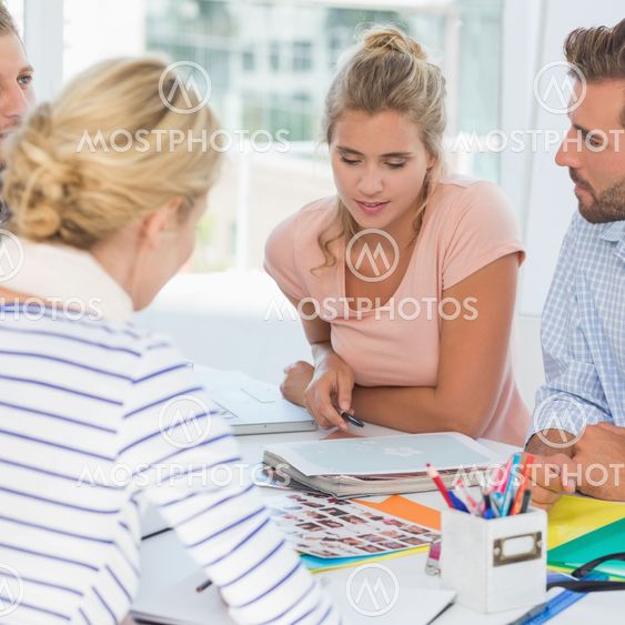 Happy design team going over contact sheets at a meeting