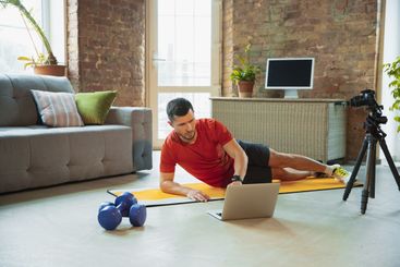 Young caucasian man training at home during quarantine...