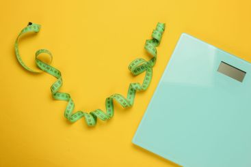 The concept of losing weight. Scales with measuring tape...