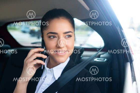 Businesswoman talking on phone in car.