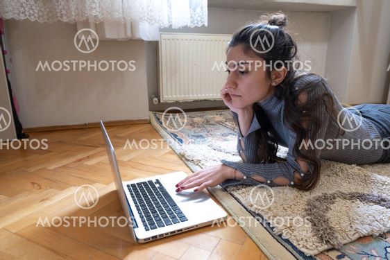 female worker checking internet and studying while lying...