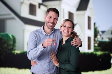 Portrait Of Happy Young Family Standing In Front