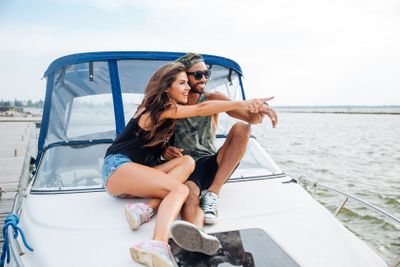 Couple sitting and pointing away on yacht