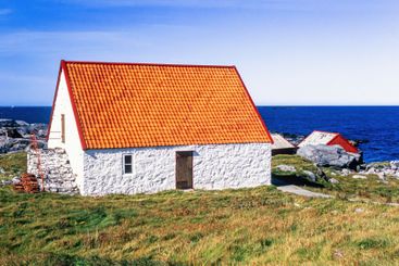 Old idyllic cottage by the sea in summer