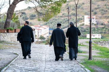 Orthodox Christian men walking at the castle of Berat,...