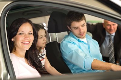 Family sitting in car in retail store