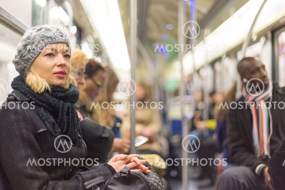 Woman traveling by subway full of people.