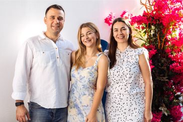 A cute teenager and her parents in fancy clothes are...