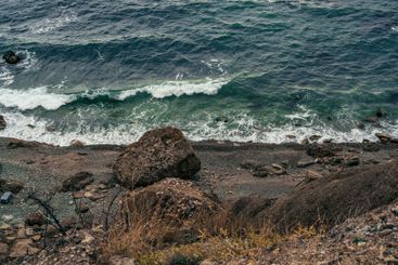 Waves crashing on a rocky shoreline under a cloudy sky...