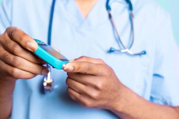 Medical expert measuring sugar from blood with a finger...