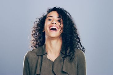 Woman, portrait and laughing for success in studio, joy...