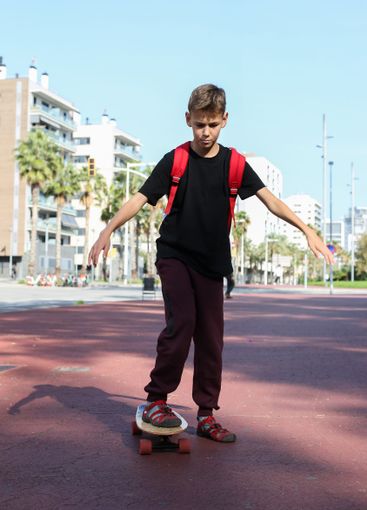 Handsome teenager standing with skateboard. Adolescent...