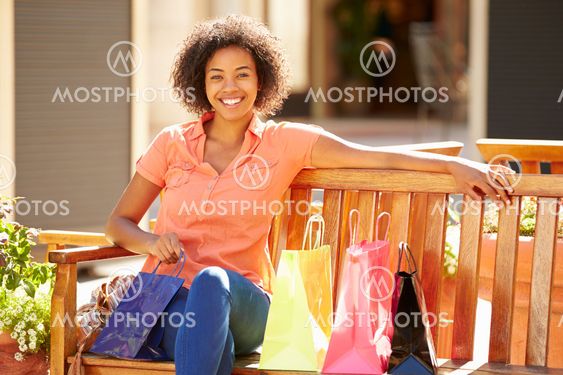 Woman Resting With Shopping Bags Sitting In Mall
