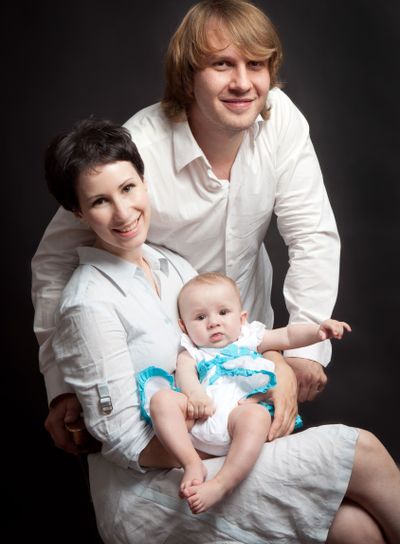 Parents hold their baby studio
