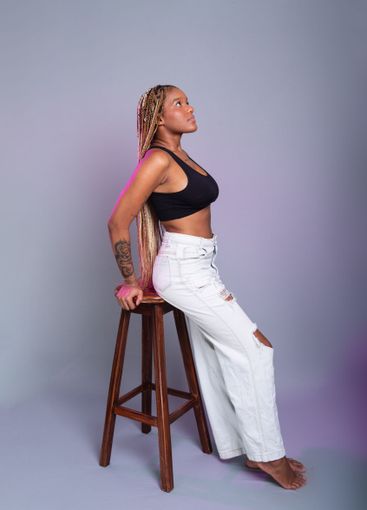 Brunette model with braids in her hair, wearing white...