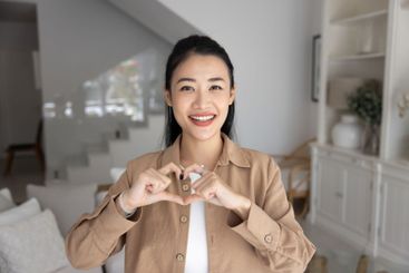 Happy beautiful young Asian blogger woman showing...