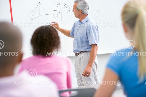 A teacher talks to school children in a high school class
