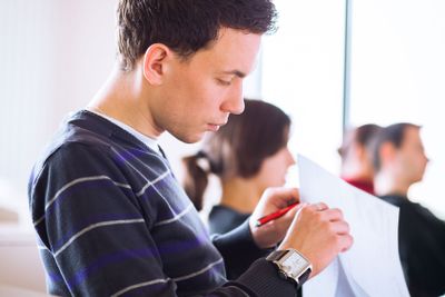 young, handsome male college student sitting in a...